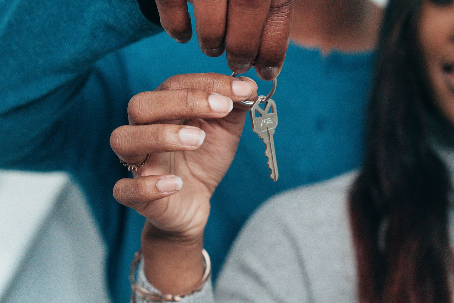 Close-up of a couple holding a new house key after completing on a home purchase, representing the point at which a buyer chooses between an interest-only or principal-and-interest mortgage