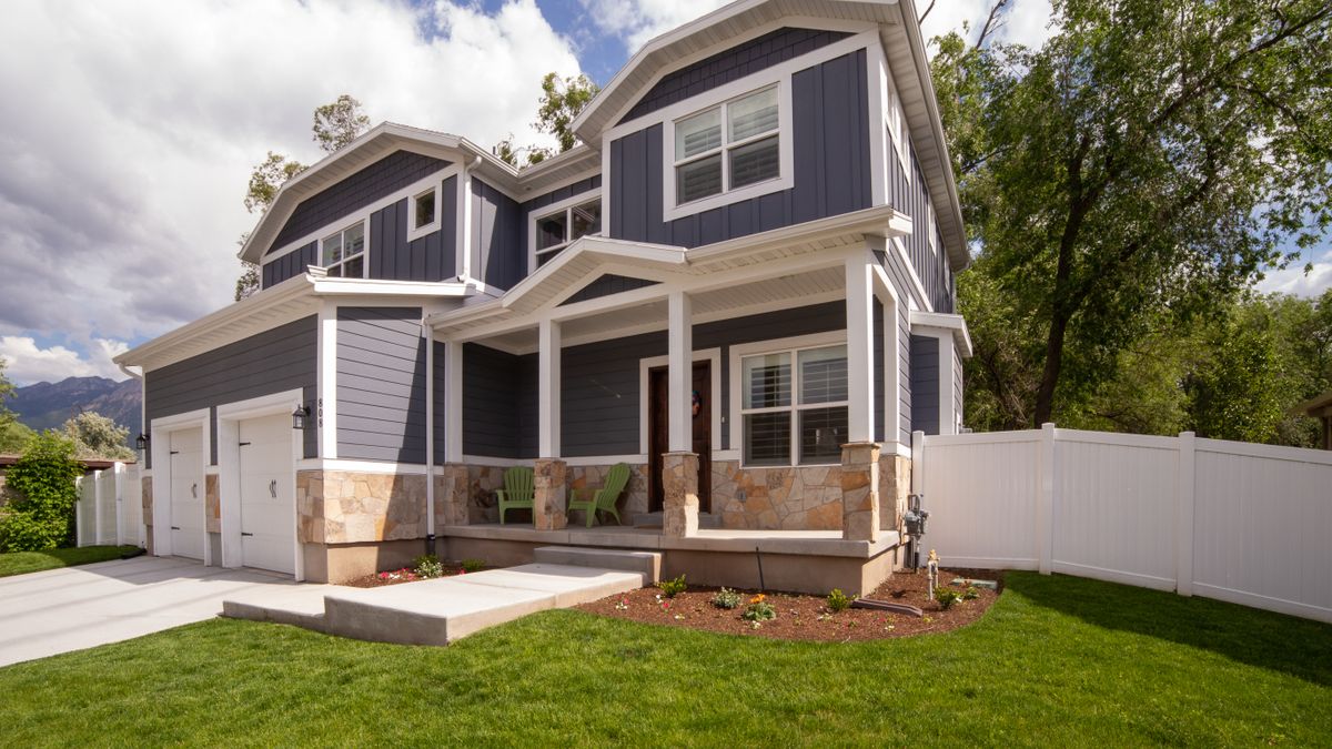 A modern two-storey American house with a front porch and attached garage, illustrating an article on how private mortgage insurance is calculated on a US conventional loan