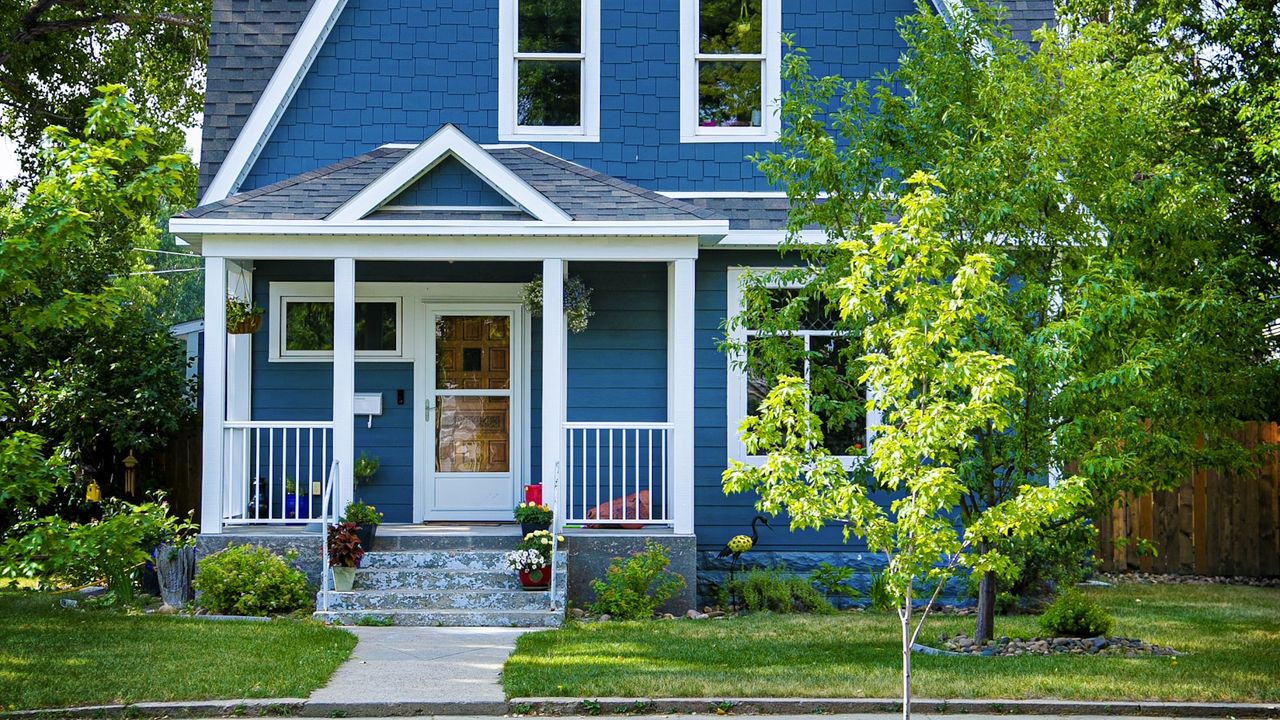 A blue weatherboard house with a white porch, front steps and a small garden, the kind of first home a KiwiSaver withdrawal is typically put towards